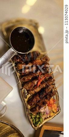 Homemade beef Satay marinated with spice and sweet soy sauce, coriander beef satay, served on plate with onion, chilli, soy sauce and tomato Homemade beef Satay marinated with spice and sweet soy sauce, coriander beef satay, served on plate with onion, chilli, soy sauce and tomato 113074029