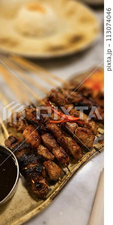 Homemade beef Satay marinated with spice and sweet soy sauce, coriander beef satay, served on plate with onion, chilli, soy sauce and tomato Homemade beef Satay marinated with spice and sweet soy sauce, coriander beef satay, served on plate with onion, chilli, soy sauce and tomato 113074046
