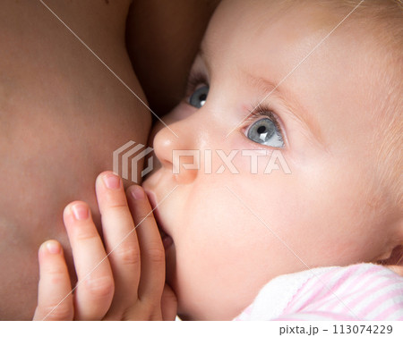 little baby sucking breast mother with open eyes little baby sucking breast mother with open eyes 113074229