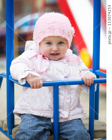 cute little baby swinging at the park 113074253