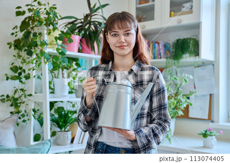 Young teenage woman watering pots with plants from watering can 113074405