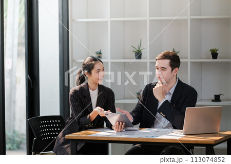 Company CEO and Top Manager Talking, Using Laptop Computer in office. Two Successful Professional People Brainstorm, Find Solution to Their e-Commerce Software Investment Strategy Company CEO and Top Manager Talking, Using Laptop Computer in office. Two Successful Professional People Brainstorm, Find Solution to Their e-Commerce Software Investment Strategy 113074852
