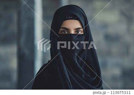 Muslim woman wearing niqab and looking at camera Muslim woman wearing niqab and looking at camera 113075311