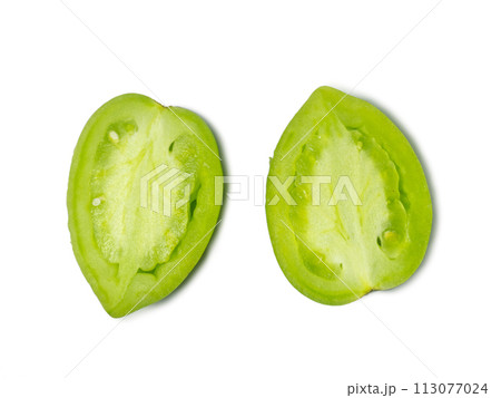 Green tomatoes on a white background. The concept of an unripe vegetable. Half cut tomato. Salting product. Healthy food. Tomatoes lady's fingers. Green tomatoes on a white background. The concept of an unripe vegetable. Half cut tomato. Salting product. Healthy food. Tomatoes lady's fingers. 113077024