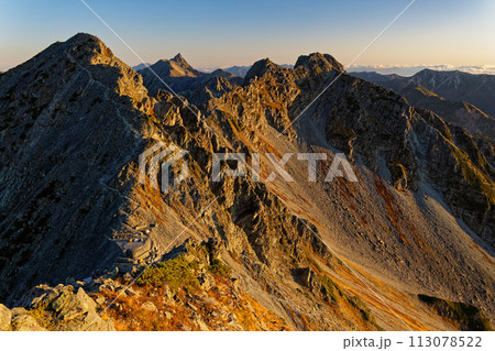 奥穂高岳への登りから見る朝焼けの涸沢岳・北穂高岳と槍ヶ岳 113078522