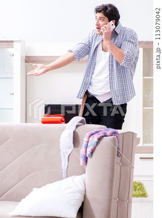 Man with mess at home after house party 113079042