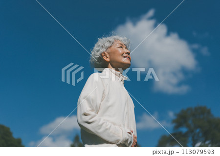 空を見上げるジャージ姿のシニア女性 空を見上げるジャージ姿のシニア女性 113079593