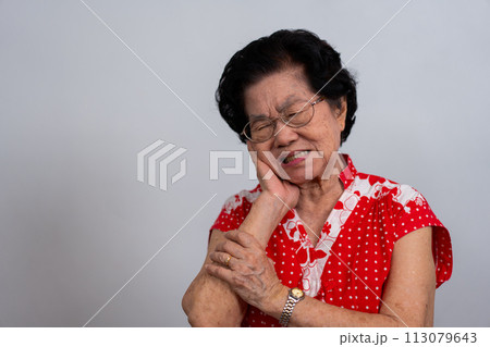 Asia old senior woman suffering from severe toothache, holding her cheek and suffering strong dental pain on white background, tooth decay, tooth sensitivity, oral health care concept. 113079643