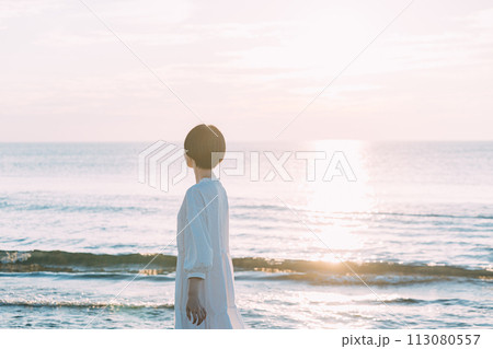 夕暮れの海を眺める女性 113080557