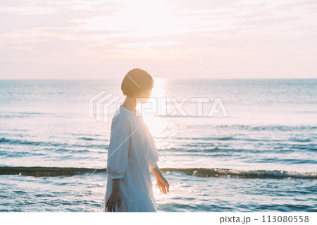 夕暮れの海を眺める女性 113080558