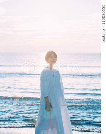 夕暮れの海を眺める女性 113080559