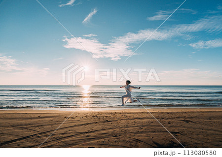 海に沈む太陽と女性のシルエット 113080580