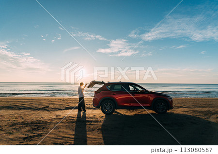 砂浜と赤い車と男性 砂浜と赤い車と男性 113080587