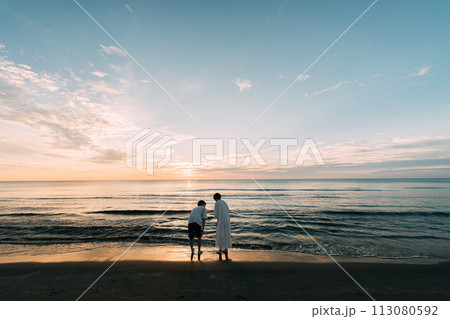 美しい海岸の夕日とカップル 113080592