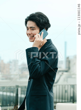 スマホで通話する若いビジネスマン スマホで通話する若いビジネスマン 113081146