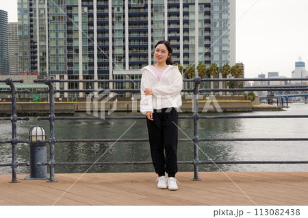 川沿いの遊歩道で休憩する女性 113082438