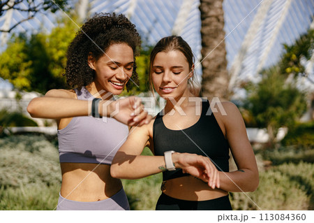 Young fit women looking at smartwatch and counting calories burned. Healthy life concept  113084360