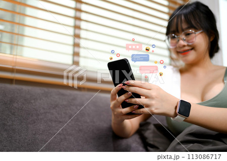 Happy young sports woman using mobile phone for commenting in online community 113086717