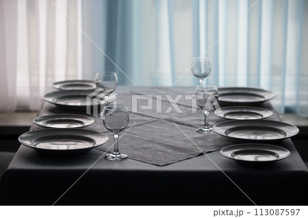 Table in the restaurant with empty plates and glass goblets.Empty table in the restaurant Table in the restaurant with empty plates and glass goblets.Empty table in the restaurant 113087597