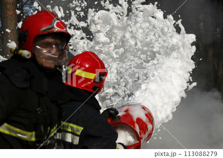 Firefighter extinguishes a fire..Extinguishing the fire. Fill the foam with a fire. Resolute firefighters. Firefighter extinguishes a fire..Extinguishing the fire. Fill the foam with a fire. Resolute firefighters. 113088279