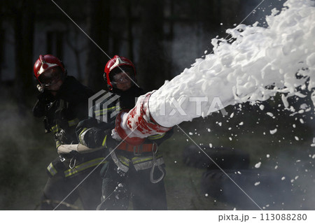 Extinguishing the fire. Firemen are working. Fill the foam with a fire. Resolute firefighters. Fight fire. Extinguishing the fire. Firemen are working. Fill the foam with a fire. Resolute firefighters. Fight fire. 113088280
