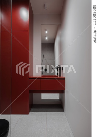 A bathroom featuring a red sink and black toilet fixture A bathroom featuring a red sink and black toilet fixture 113088689