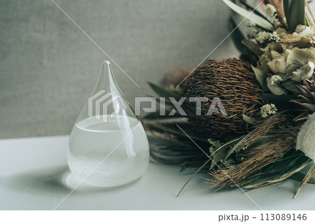 テーブルの上に置いてあるドライフラワーとストームグラス 113089146