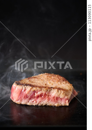 牛もも肉のステーキを鉄板で焼く 113090115