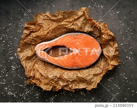 Raw salmon steak on a parchment paper Raw salmon steak on a parchment paper 113090355