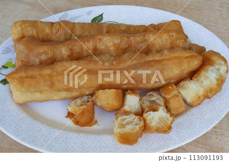 Top view of cakoi or Youtiao on white plate. Asian food concept Top view of cakoi or Youtiao on white plate. Asian food concept 113091193