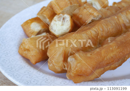 Delicious cakoi or youtiao cake on white plate. Asian food concept Delicious cakoi or youtiao cake on white plate. Asian food concept 113091199