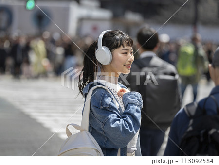 ヘッドホンをした笑顔の若い女性 113092584