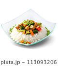 A flavorful and aromatic stir-fry in a square glass dish, garnished with sliced scallions 113093206
