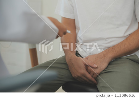 Male diseases. Man presses hands to his groin and suffering from pain, panorama, cropped, studio shot 113096616