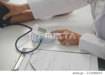 Male doctor uses a blood pressure monitor to check the body pressure and pulse of the patients who come to the hospital for check-ups, Medical treatment and health care concept. 113096647
