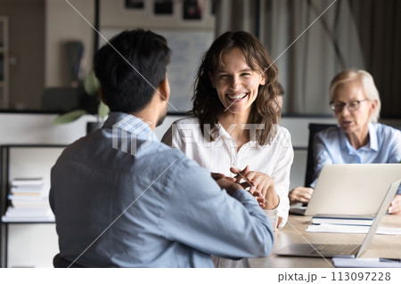 Cheerful young employee woman discussing project with colleague at meeting Cheerful young employee woman discussing project with colleague at meeting 113097228