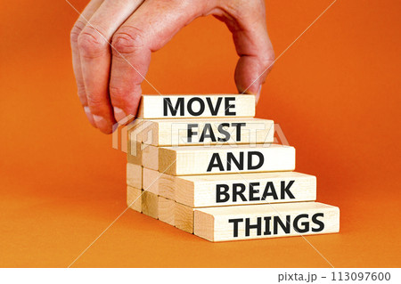 Move fast and break things symbol. Concept words Move fast and break things on wooden blocks. Beautiful orange background. Businessman hand. Business, move fast and break things concept. Copy space. 113097600