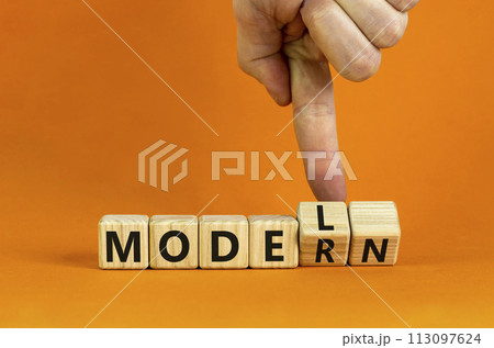 Modern model symbol. Businessman turns wooden cubes and changes the word 'model' to 'modern'. Beautiful orange table, orange background, copy space. Business and modern model concept. Modern model symbol. Businessman turns wooden cubes and changes the word 'model' to 'modern'. Beautiful orange table, orange background, copy space. Business and modern model concept. 113097624