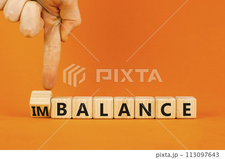 Balance or imbalance symbol. Concept word Imbalance or Balance on beautiful wooden cubes. Beautiful orange background. Businessman hand. Business balance or imbalance concept. Copy space. Balance or imbalance symbol. Concept word Imbalance or Balance on beautiful wooden cubes. Beautiful orange background. Businessman hand. Business balance or imbalance concept. Copy space. 113097643