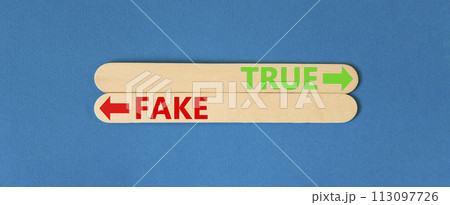 True or fake symbol. Concept word True or Fake on beautiful wooden stick. Beautiful blue table blue background. Business and true or fake concept. Copy space. 113097726