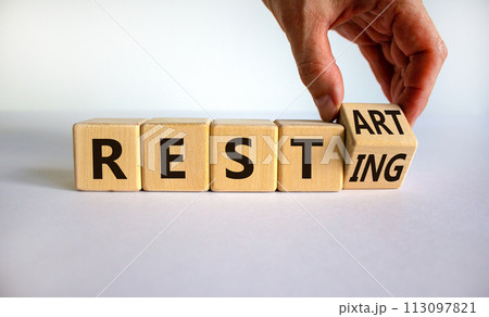 Symbol for the end of the quarantine period. Male hand flips a wooden cube and changes the inscription 'resting' to 'restart'. Beautiful white background, copy space. Business concept. Symbol for the end of the quarantine period. Male hand flips a wooden cube and changes the inscription 'resting' to 'restart'. Beautiful white background, copy space. Business concept. 113097821