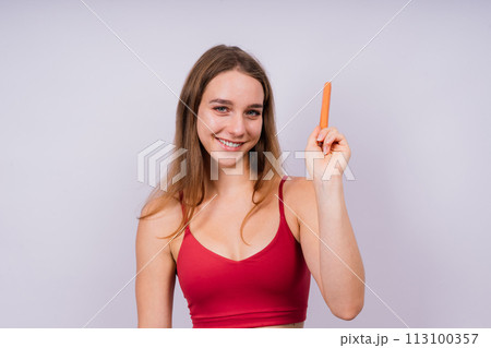 Close-up of a woman eating a sausage. Cropped photo in studio 113100357