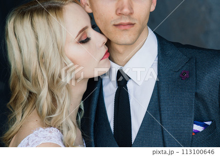 Cute wedding couple in interior of classic studio. They kiss and hug each other. 113100646