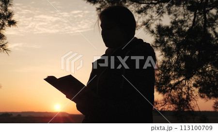 girl woman praying at sunset, hand sunset faith pain, asking heaven for help, bible book, young adult prayer, devout sunset reflection, peaceful prayer session, solitude prayer evening, spiritual 113100709