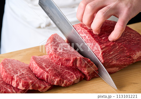 国産の黒毛和牛もも肉(シンシン)をカットする料理人 国産の黒毛和牛もも肉(シンシン)をカットする料理人 113101221