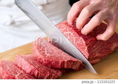 国産の黒毛和牛もも肉（シンシン）をカットする料理人 113101225