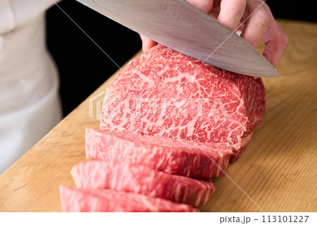 国産の黒毛和牛もも肉（シンシン）をカットする料理人 113101227