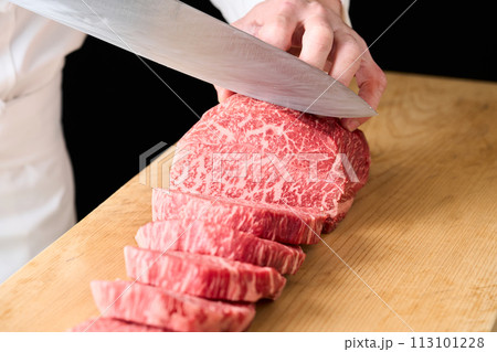 国産の黒毛和牛もも肉(シンシン)をカットする料理人 国産の黒毛和牛もも肉(シンシン)をカットする料理人 113101228
