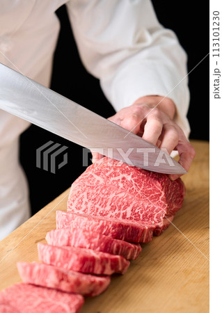 国産の黒毛和牛もも肉（シンシン）をカットする料理人 113101230