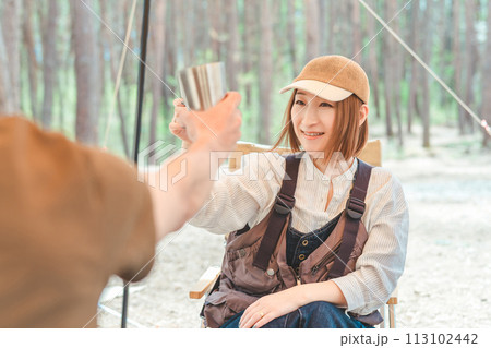 キャンプ場でステンレスカップでビールを飲む夫婦・カップルキャンパー キャンプ場でステンレスカップでビールを飲む夫婦・カップルキャンパー 113102442